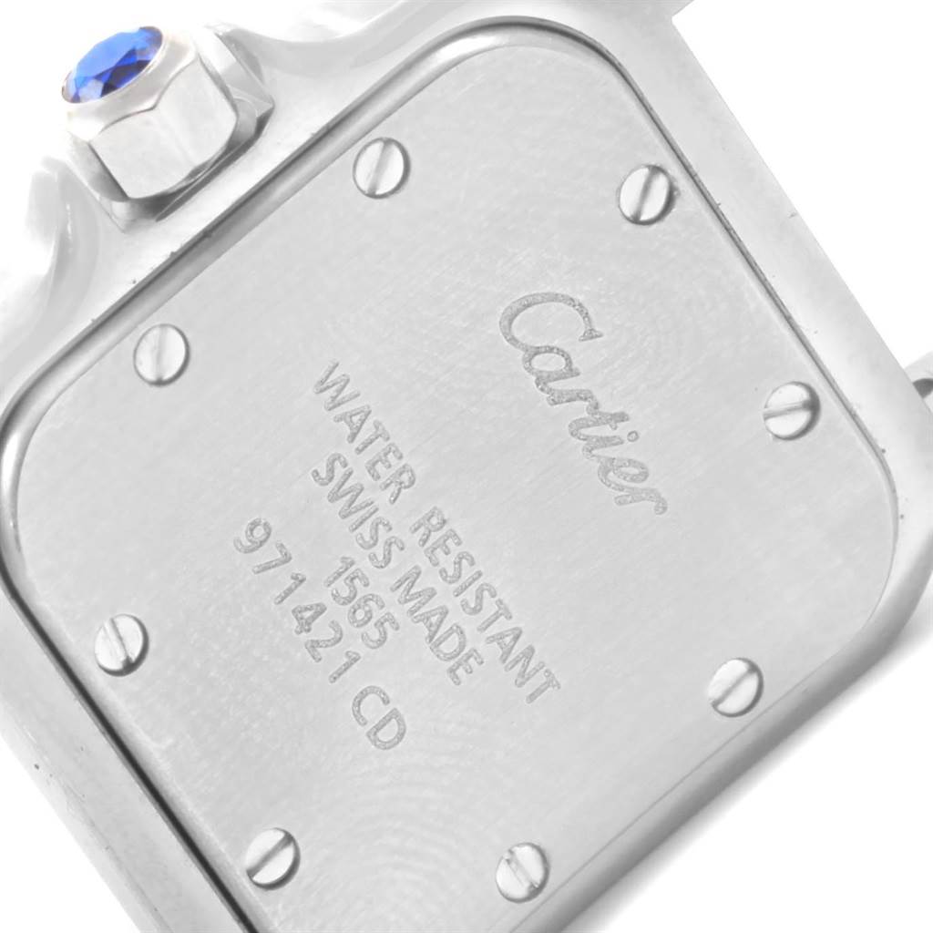 This image shows the case back and crown of the Cartier Santos W20056D6 Women's Stainless Steel Silver Dial W20056D6 Women's Stainless Steel Silver Dial watch, featuring engraved details and a blue-tipped crown.