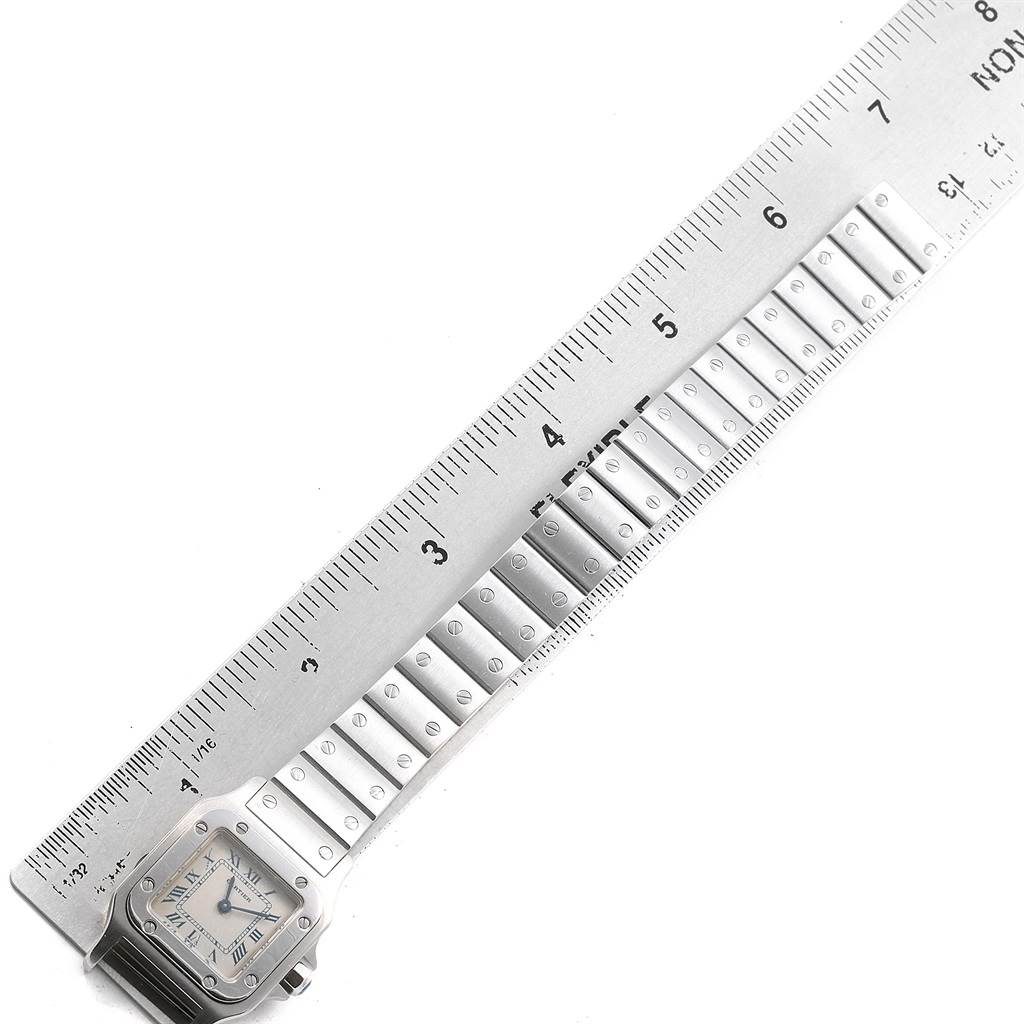 The image shows the face and band of a Cartier Santos 1565 Women's Stainless Steel Silver Dial 1565 Women's Stainless Steel Silver Dial watch, measured against a ruler.