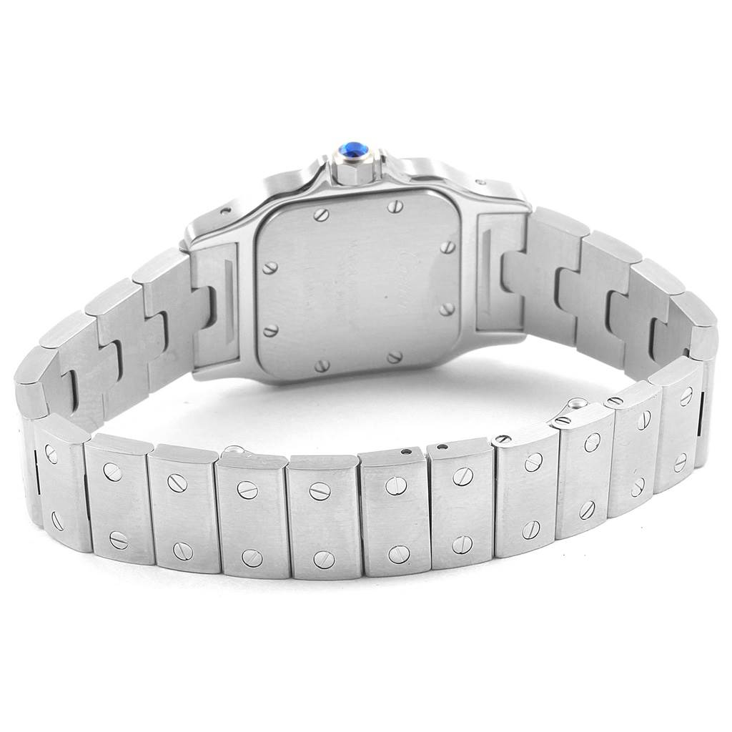 The image shows the back view of a Santos model by Cartier, featuring its metal bracelet and case back.