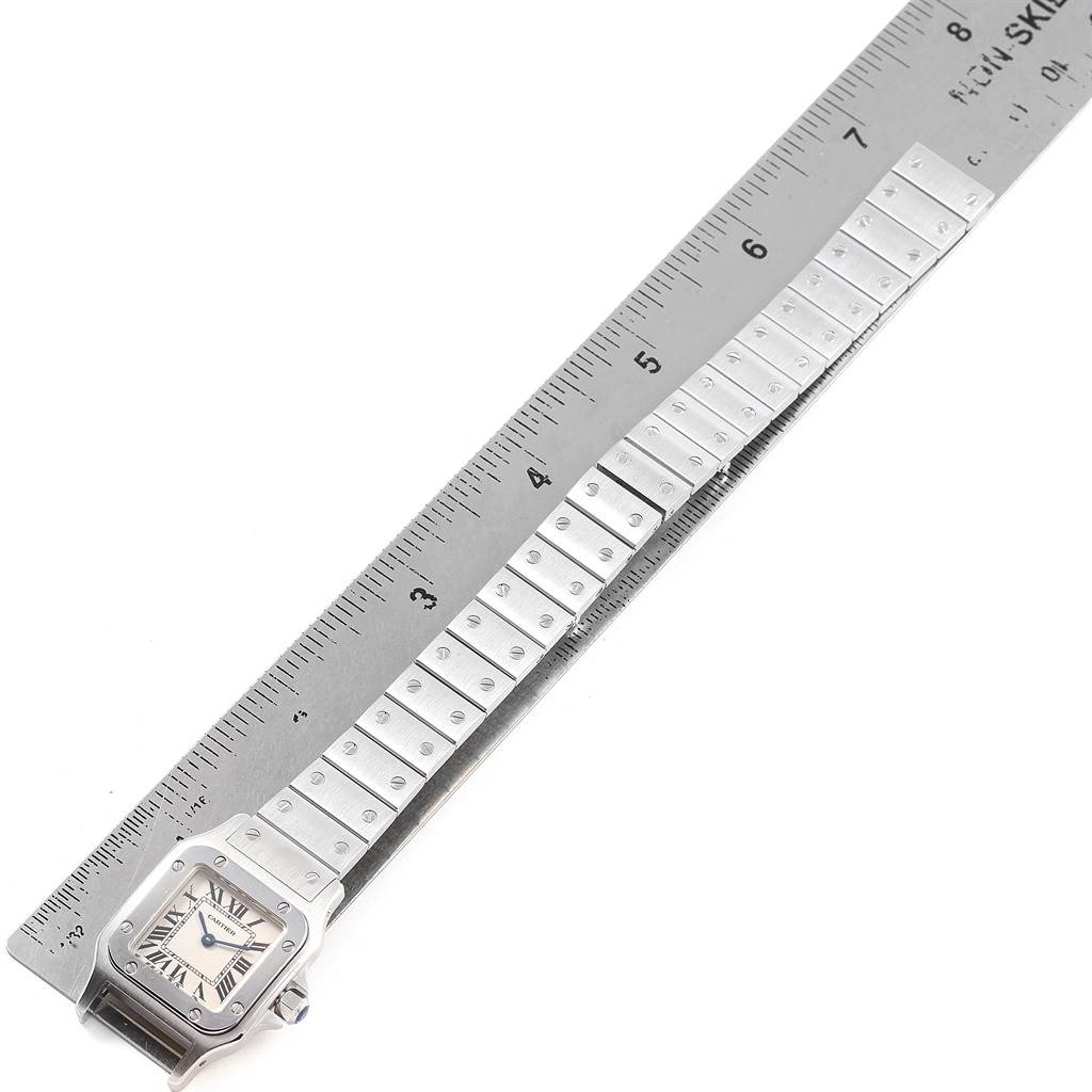 The image shows a Cartier Santos W20056D6 Women's Stainless Steel Silver Dial W20056D6 Women's Stainless Steel Silver Dial watch, with the face and full metal band, alongside a ruler for measurement.