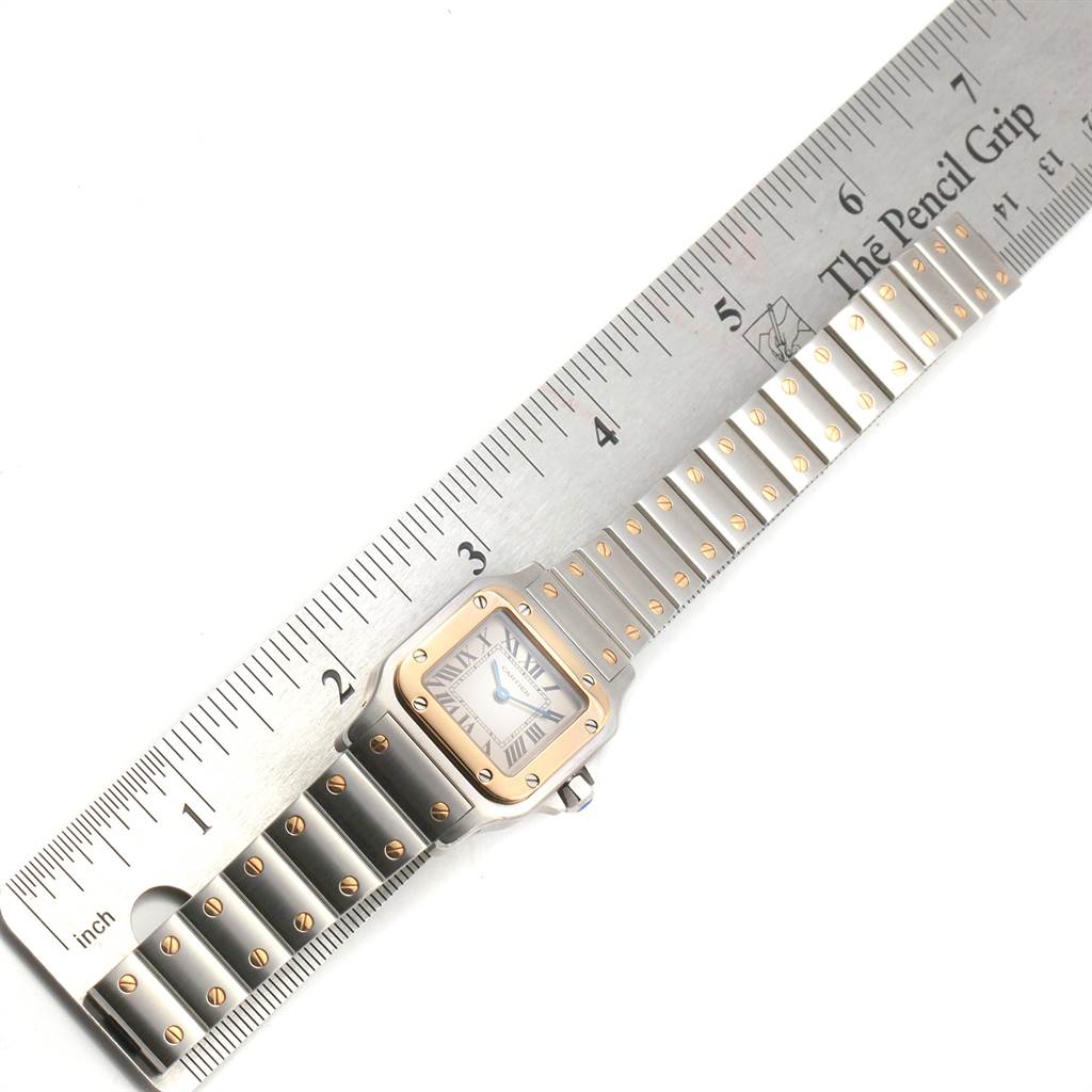 The image shows the Santos model by Cartier laying flat, with a ruler beside it for size comparison.