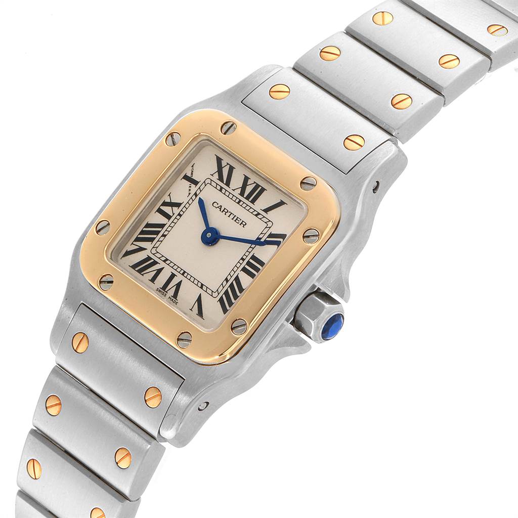 The image shows a close-up of the face, bezel, and part of the band of a Santos model watch by Cartier.