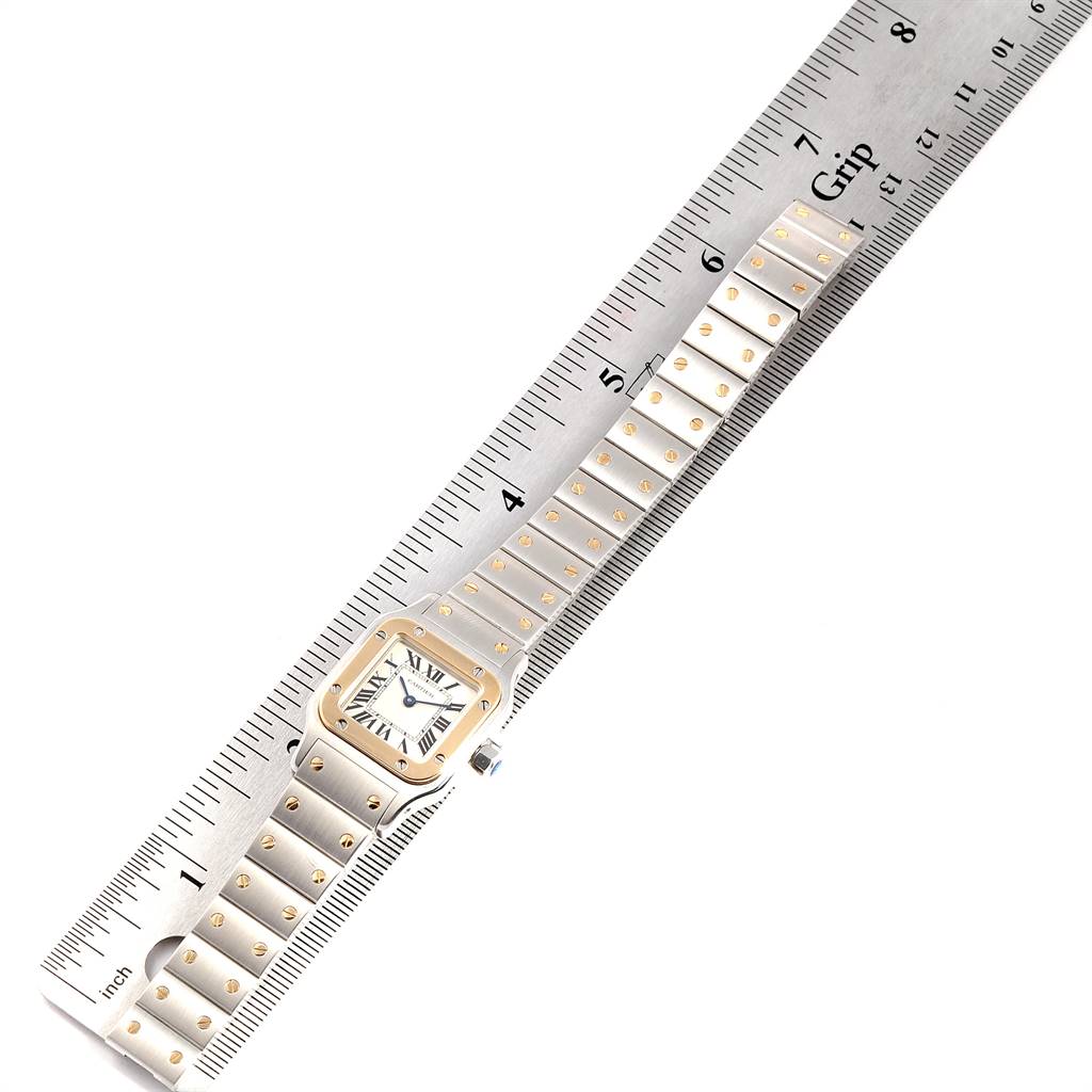 This image shows a Cartier Santos W20012C4 Women's Stainless Steel Silver Dial W20012C4 Women's Stainless Steel Silver Dial watch laid flat against a ruler, with the face and bracelet visible.