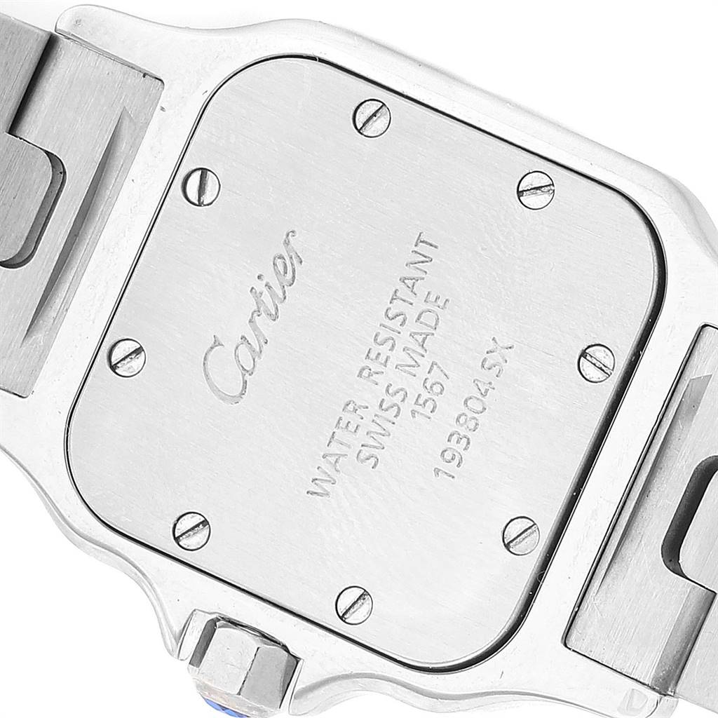 The image shows the back case of a Cartier Santos W20012C4 Women's Stainless Steel Silver Dial W20012C4 Women's Stainless Steel Silver Dial model watch, highlighting screws, inscriptions, and part of the bracelet.