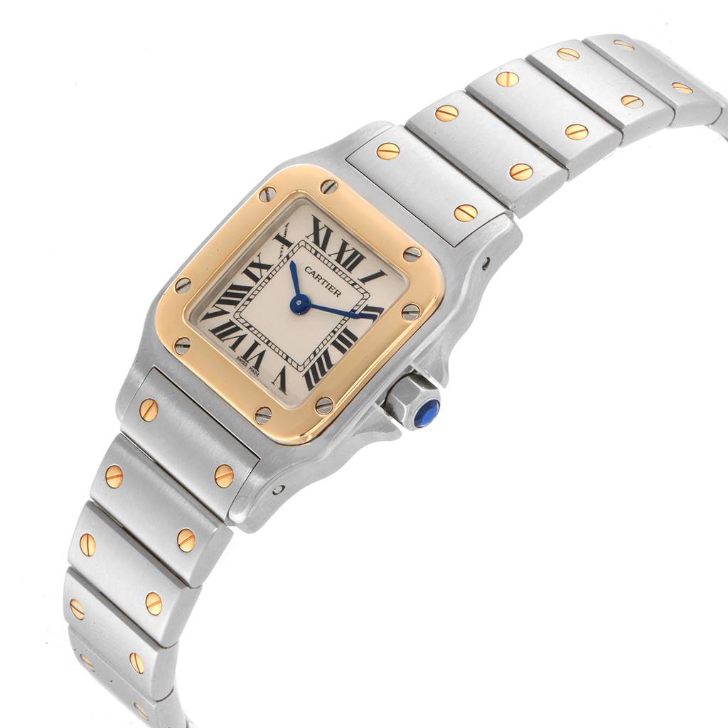 The image shows a side angle of a Cartier Santos W20012C4 Women's Stainless Steel Silver Dial W20012C4 Women's Stainless Steel Silver Dial watch, displaying its band, gold screws, square face, and blue crown.