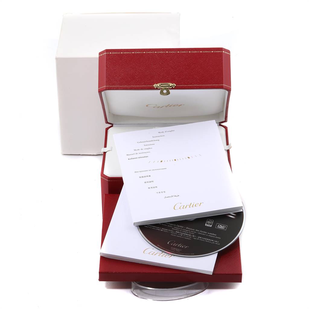 The image shows the outer packaging, instruction manual, DVD, and presentation box for a Santos model by Cartier.
