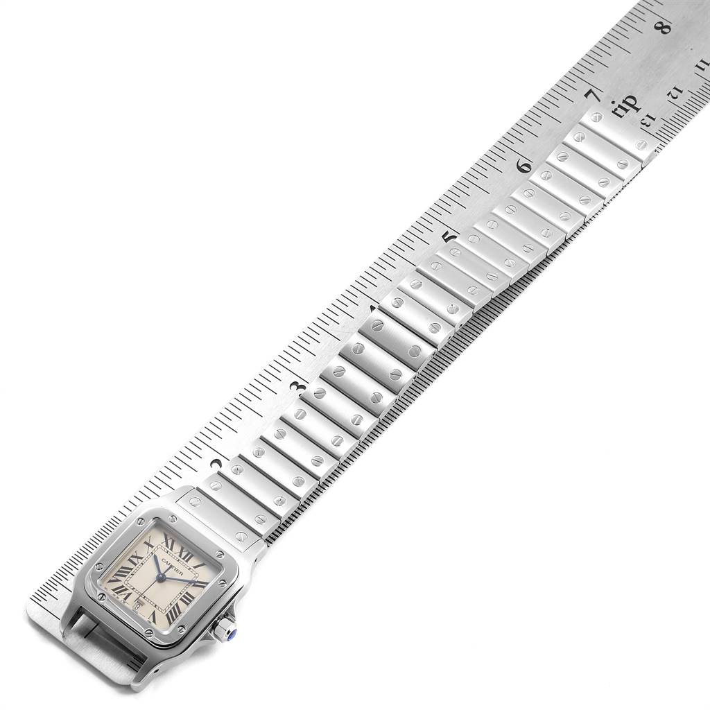 The image shows a Cartier Santos W20060D6 Stainless Steel Silver Dial W20060D6 Stainless Steel Silver Dial watch placed diagonally with its bracelet aligned along a ruler, displaying the face and band.