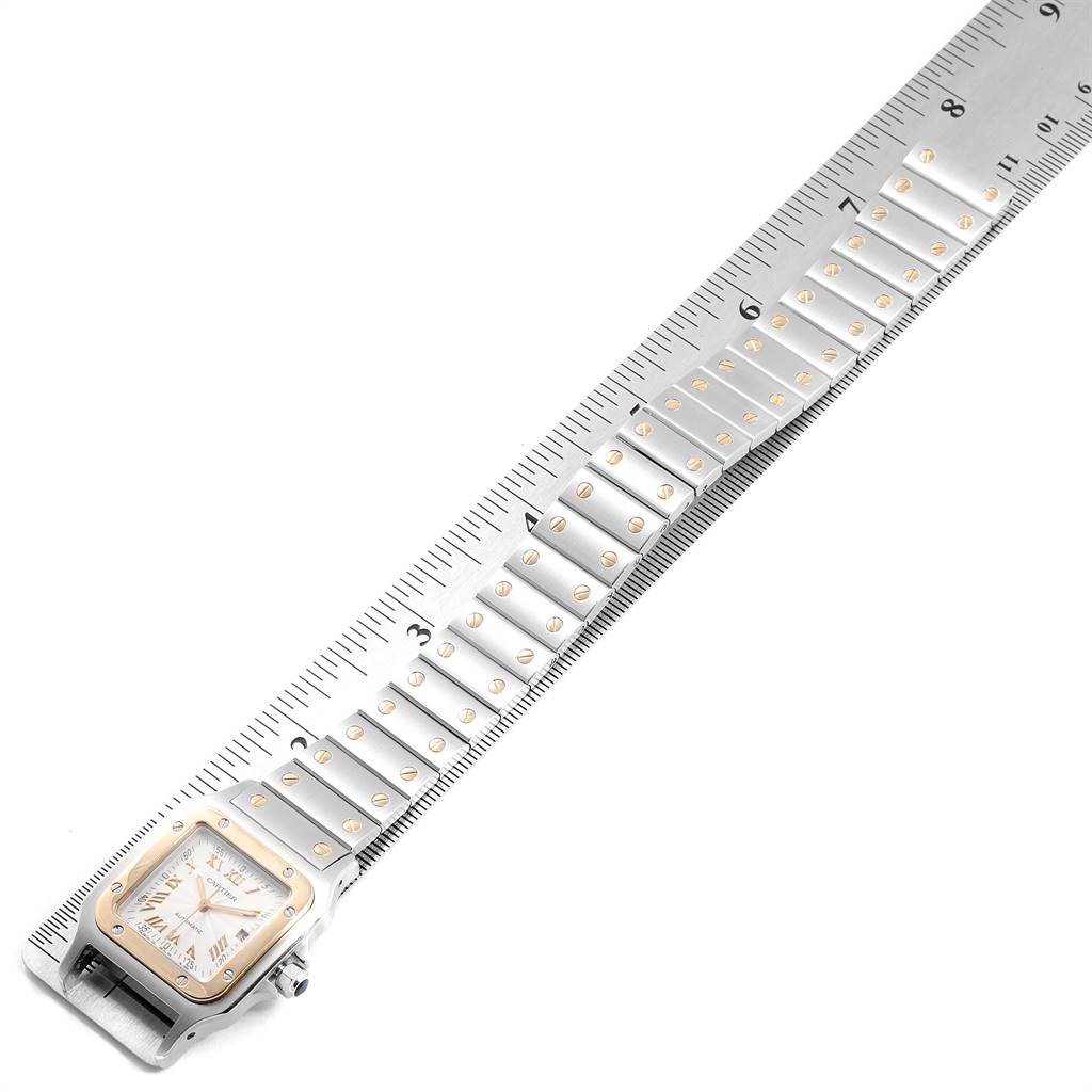 The image shows a Cartier Santos W20058C4 Men's Stainless Steel Silver Dial W20058C4 Men's Stainless Steel Silver Dial watch with its face and full bracelet band laid next to a measuring ruler.