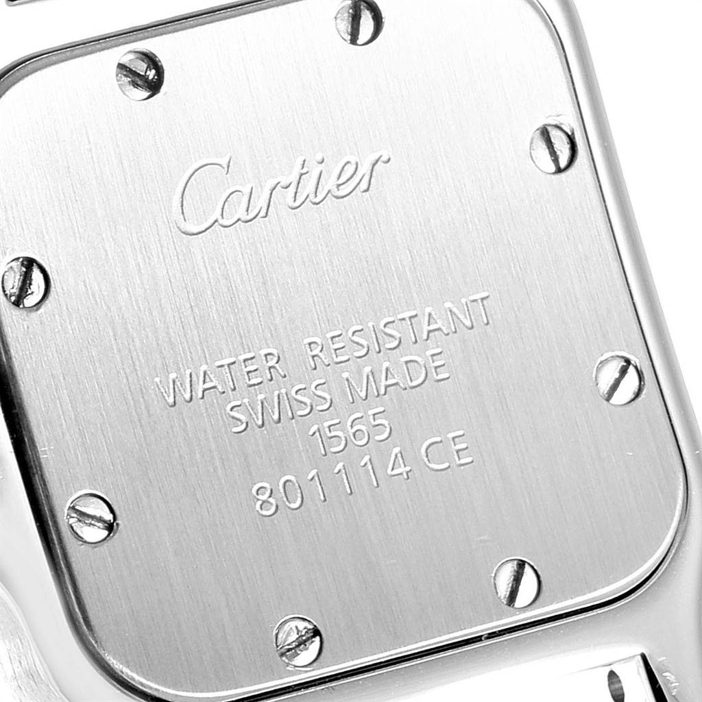 The image shows the stainless steel case back of a Santos model by Cartier, highlighting the engraved brand and specifications.