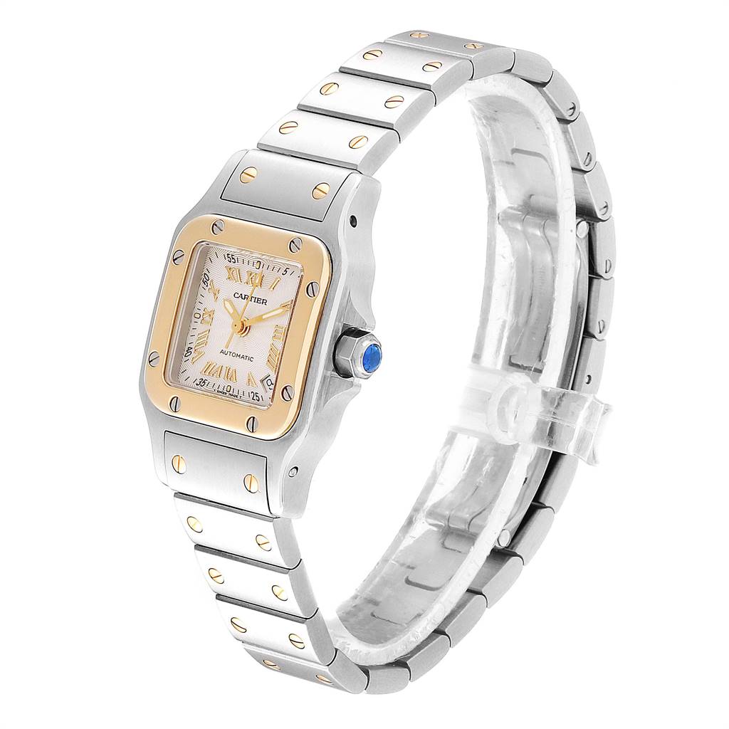 The Cartier Santos W20057C4 Women's Stainless Steel Silver Dial W20057C4 Women's Stainless Steel Silver Dial watch is shown from a side angle, highlighting its metal bracelet, square face, and crown with a blue gem.