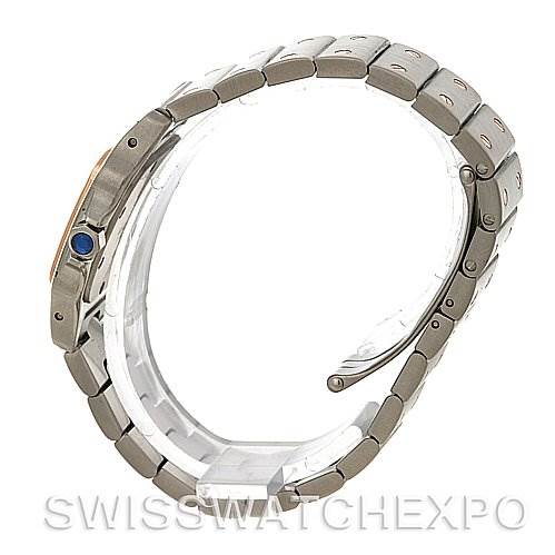 The image shows a Cartier Santos W20012C4 Women's Stainless Steel Mother of Pearl Dial W20012C4 Women's Stainless Steel Mother of Pearl Dial model watch from a side angle, highlighting its bracelet and crown with a blue sapphire cabochon.