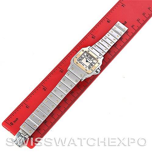 The image displays a Cartier Santos W20012C4 Women
s Stainless Steel Silver Dial W20012C4 Women
s Stainless Steel Silver Dial watch placed flat and measured against a red ruler.
