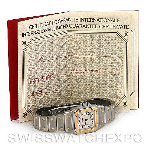 The image shows a Cartier Santos W20012C4 Women
s Stainless Steel Silver Dial W20012C4 Women
s Stainless Steel Silver Dial watch placed horizontally in front of an International Limited Guarantee Certificate.