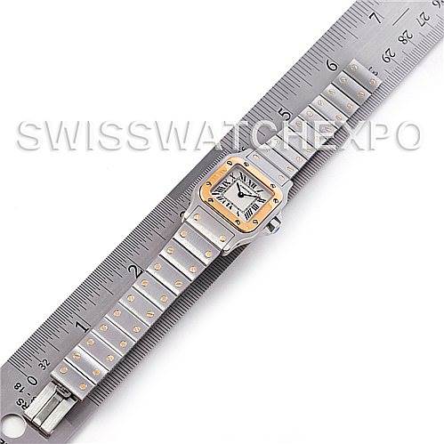 The image shows the full front view of a Santos model Cartier watch, laid flat on a ruler.
