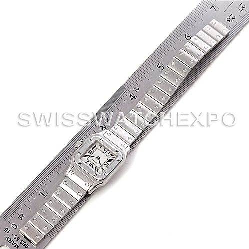 The Cartier Santos W20056D6 Women
s Stainless Steel Silver Dial W20056D6 Women
s Stainless Steel Silver Dial watch is shown fully extended alongside a ruler for measurement, displaying its face and bracelet.