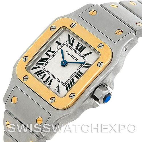 This image shows the Santos model watch by Cartier from a front angle, highlighting its gold bezel, Roman numeral dial, and steel bracelet with gold screws.