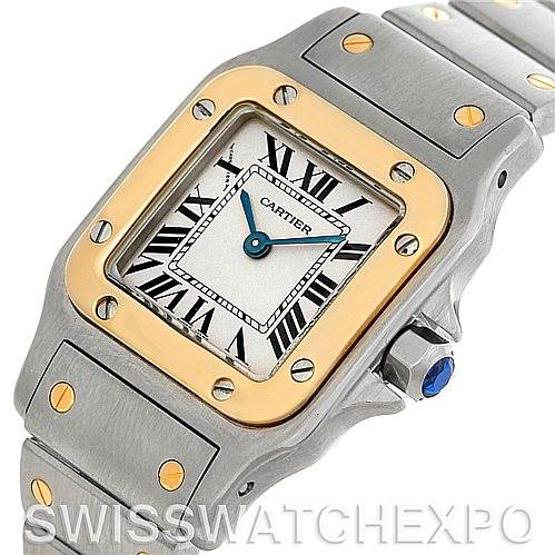 This image shows a close-up of the face and bracelet of the Cartier Santos W20012C4 Women
s Stainless Steel Silver Dial W20012C4 Women
s Stainless Steel Silver Dial watch, highlighting its gold bezel and Roman numeral markers.