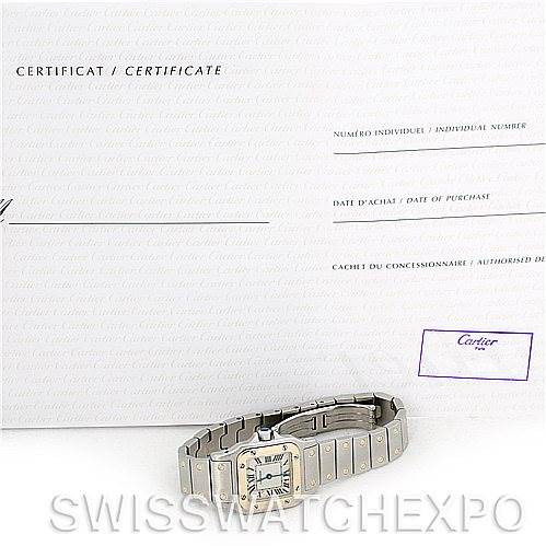 The image shows a Cartier Santos W20012C4 Women
s Stainless Steel Silver Dial W20012C4 Women
s Stainless Steel Silver Dial watch laid flat with its certification document displayed behind it.