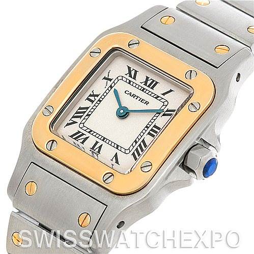 This Cartier Santos W20012C4 Women
s Stainless Steel Silver Dial W20012C4 Women
s Stainless Steel Silver Dial watch is shown from a front angle, highlighting its square face, roman numerals, gold bezel, and metal bracelet.
