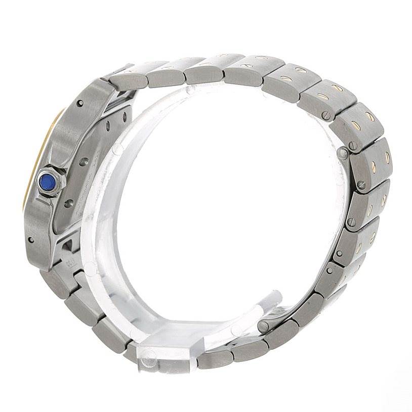 The side profile of a Cartier Santos W20045C4 Women
s Stainless Steel Silver Dial W20045C4 Women
s Stainless Steel Silver Dial watch, showing the bezel, crown with a blue gemstone, and metal bracelet.