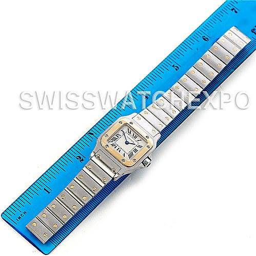 The image shows a Cartier Santos W20012C4 Women's Stainless Steel Silver Dial W20012C4 Women's Stainless Steel Silver Dial watch laid flat next to a blue ruler, displaying its face, bezel, and entire bracelet.