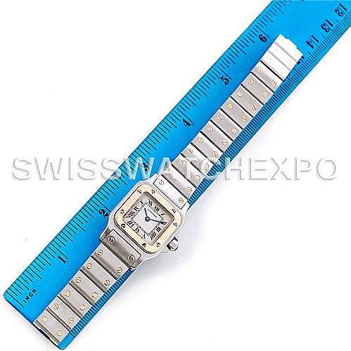 The image shows a top-down view of a Cartier Santos W20012C4 Women
s Stainless Steel Silver Dial W20012C4 Women
s Stainless Steel Silver Dial watch with a measuring ruler alongside it.