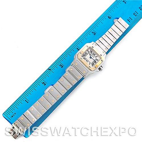 The image shows a Cartier Santos W20012C4 Women
s Stainless Steel Silver Dial W20012C4 Women
s Stainless Steel Silver Dial watch laid flat with a metal bracelet, measured against a blue ruler.