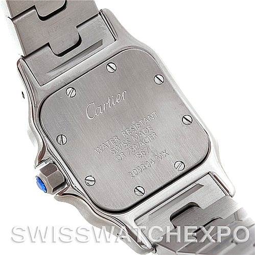 The image shows the back case and part of the bracelet of the Santos model by Cartier from an angle revealing the engravings.
