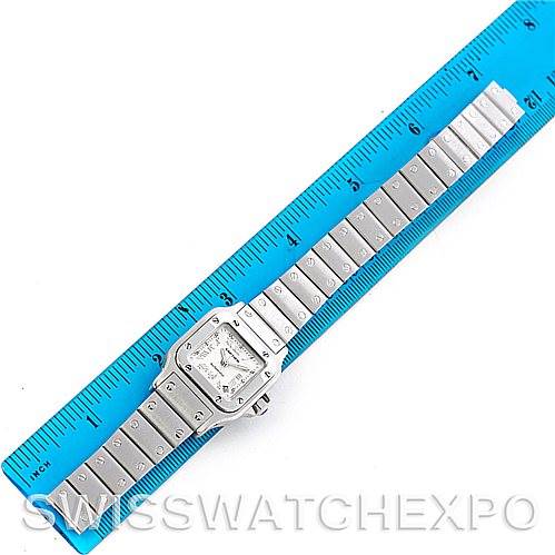 The image shows a top-down view of a Cartier Santos W20054D6 Women
s Stainless Steel Silver Dial W20054D6 Women
s Stainless Steel Silver Dial watch alongside a blue ruler for scale.