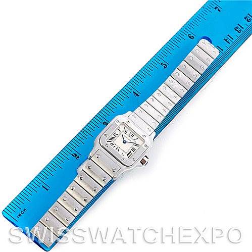 The image shows a Santos model by Cartier, displayed flat with a blue ruler measuring its length.