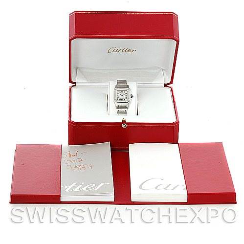 The image shows a Santos model by Cartier, displayed in an open red box with accompanying booklets and documents.