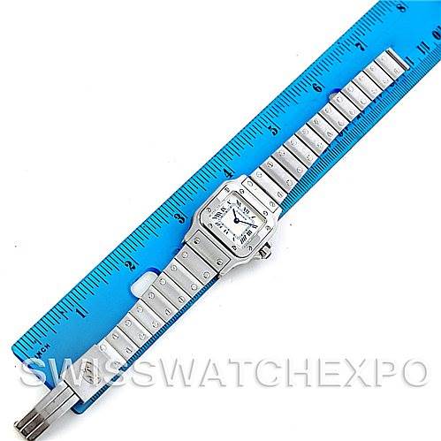 The Cartier Santos 1565 Women
s Stainless Steel Silver Dial 1565 Women
s Stainless Steel Silver Dial watch is shown from a top-down angle, laying flat against a ruler for scale.