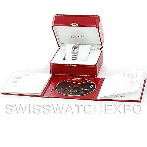 The image shows a Cartier Santos W20056D6 Women
s Stainless Steel Silver Dial W20056D6 Women
s Stainless Steel Silver Dial watch in a red box, with booklets and a CD displayed in front of it.