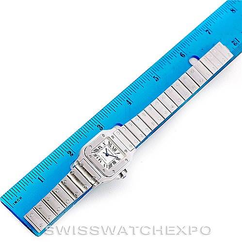 The image shows a top-down view of a Cartier Santos W20054D6 Women
s Stainless Steel Silver Dial W20054D6 Women
s Stainless Steel Silver Dial watch, placed next to a blue ruler for scale.