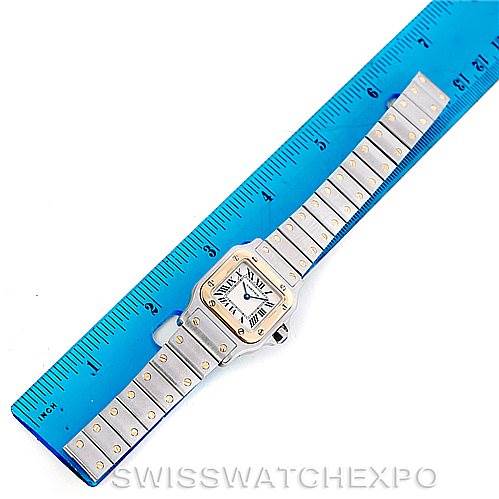 The image shows the Cartier Santos W20012C4 Women
s Stainless Steel Silver Dial W20012C4 Women
s Stainless Steel Silver Dial watch with its band laid flat next to a blue ruler for scale.