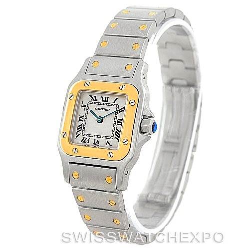 The image displays a Santos model by Cartier from an angled perspective, showcasing the watch face, bracelet, and crown.
