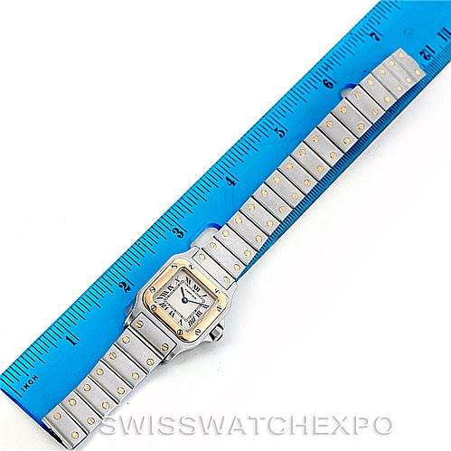 The image shows a top view of a Santos model by Cartier, including the face and full bracelet, placed beside a ruler.
