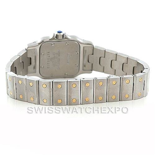The image shows the back view of the Santos model watch by Cartier, focusing on the case back and the metal bracelet with gold screws.