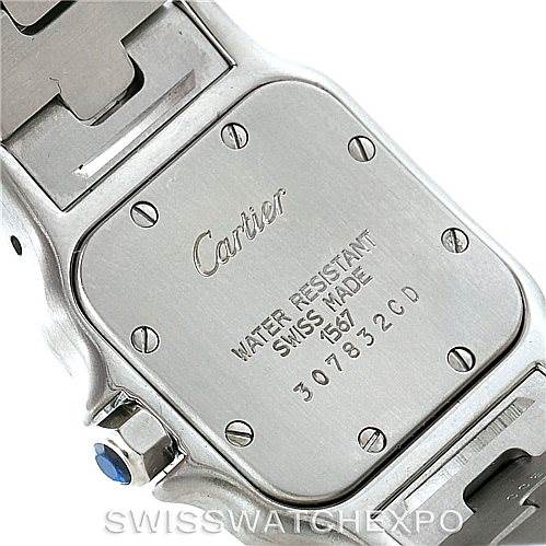 This image displays the back case of a Santos model watch by Cartier at a close-up angle, showing the engraved details and part of the bracelet.