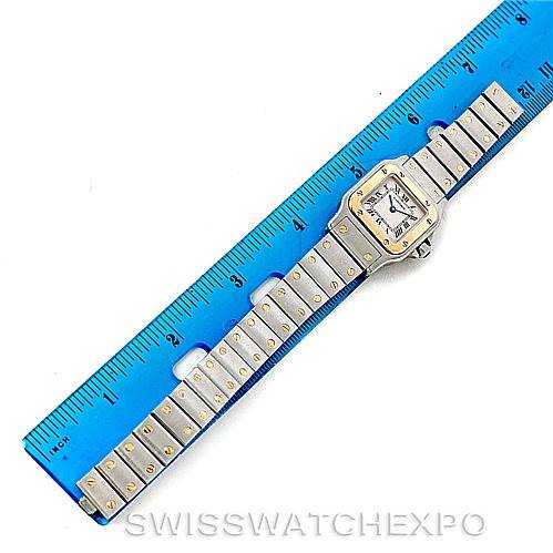 The image shows a Cartier Santos W20012C4 Women
s Stainless Steel Silver Dial W20012C4 Women
s Stainless Steel Silver Dial watch laid flat next to a blue ruler for measurement.