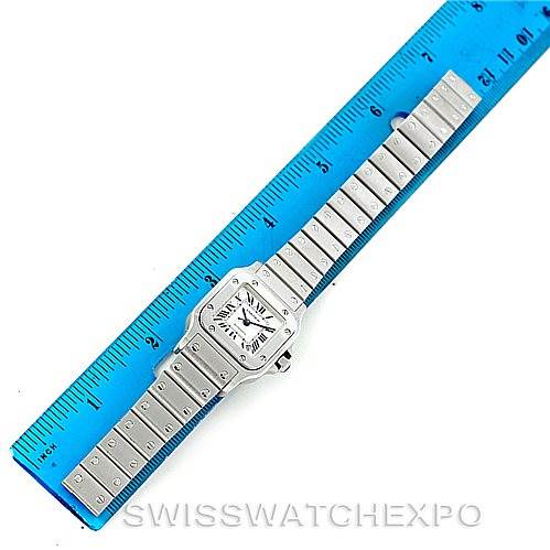 The image shows a full-view of a Cartier Santos W20054D6 Women
s Stainless Steel Silver Dial W20054D6 Women
s Stainless Steel Silver Dial model watch laid flat against a ruler, displaying the face and bracelet.