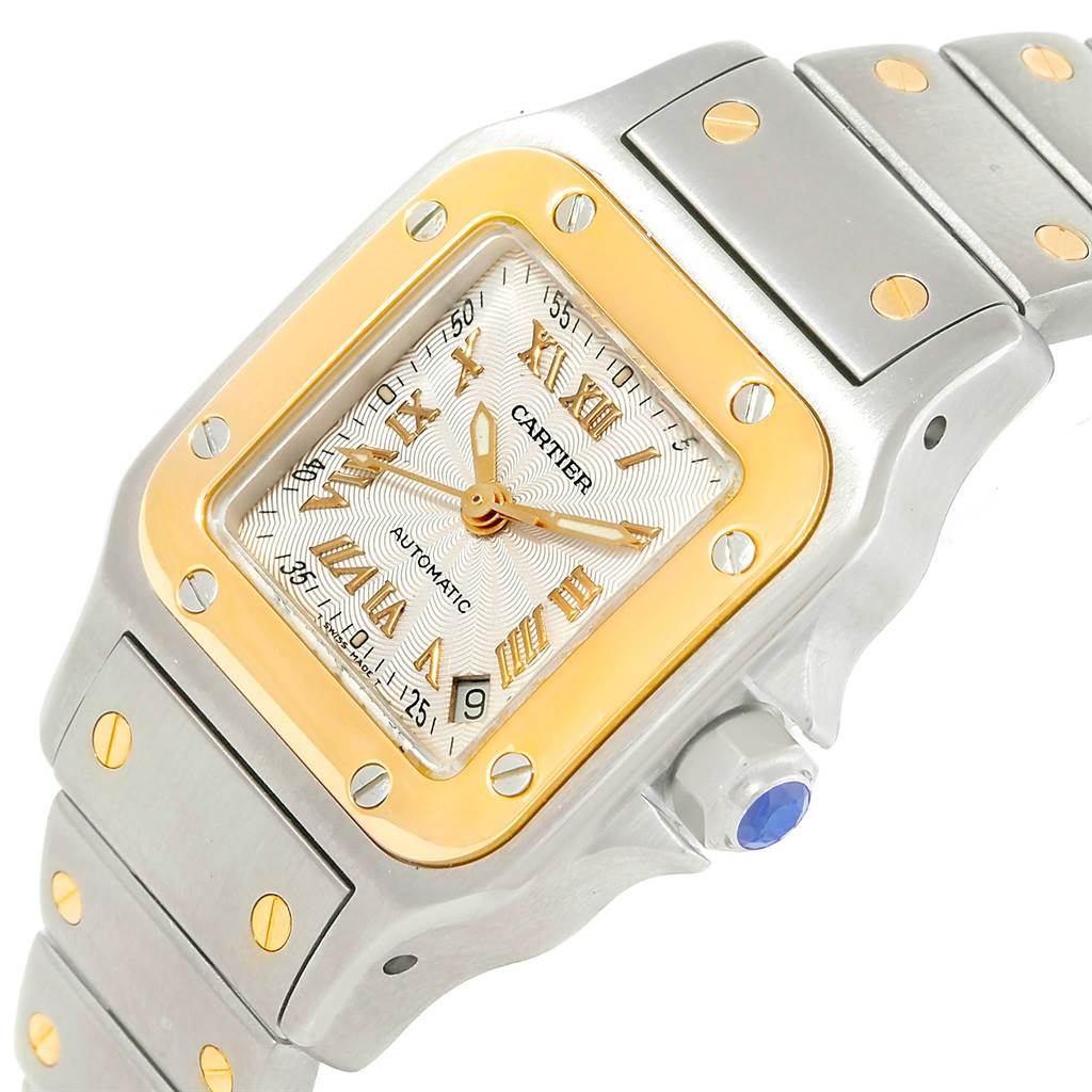 This image shows a close-up angled view of the Cartier Santos W20057C4 Women
s Stainless Steel Silver Dial W20057C4 Women
s Stainless Steel Silver Dial watch
s face and part of its bracelet.