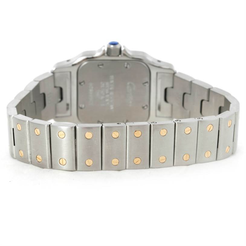 This image shows the back view of the Santos model watch by Cartier, highlighting its stainless steel band with gold screws.