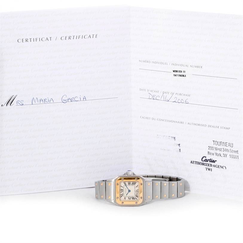 The image shows a Cartier Santos W20012C4 Women's Stainless Steel Silver Dial W20012C4 Women's Stainless Steel Silver Dial watch laying horizontally in front of its certificate.