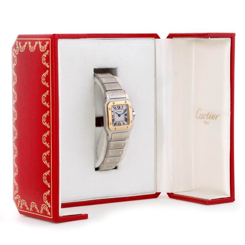 The Cartier Santos W20012C4 Women
s Stainless Steel Silver Dial W20012C4 Women
s Stainless Steel Silver Dial watch is shown upright in an open red and white watch box.