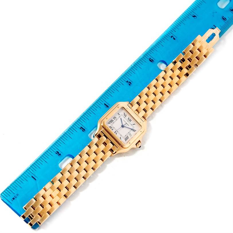 The Cartier Panthere W25014B9 Yellow Gold Silver Dial W25014B9 Yellow Gold Silver Dial watch is shown from a top-down angle, lying flat next to a blue ruler.