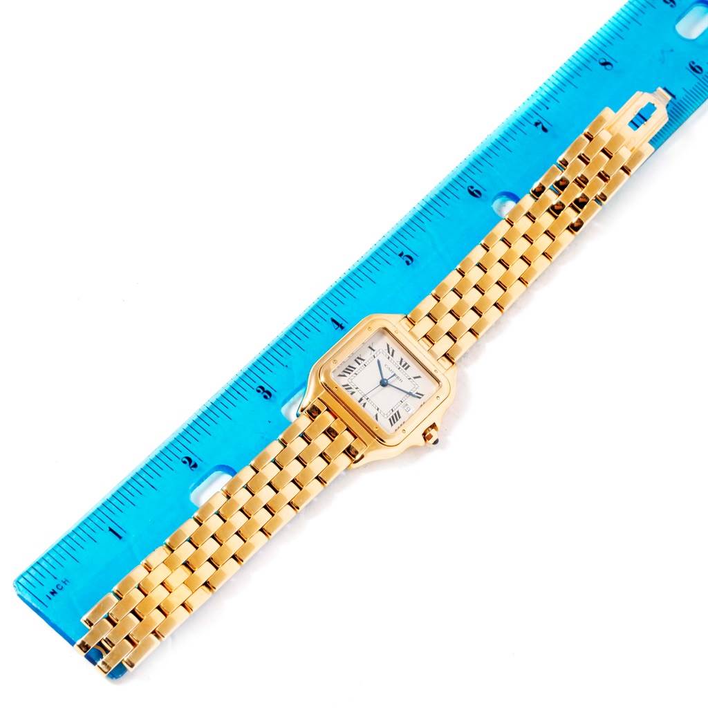 The Cartier Panthere W25014B9 Men's Yellow Gold Silver Dial W25014B9 Men's Yellow Gold Silver Dial model watch is shown fully extended next to a blue ruler for measurement.