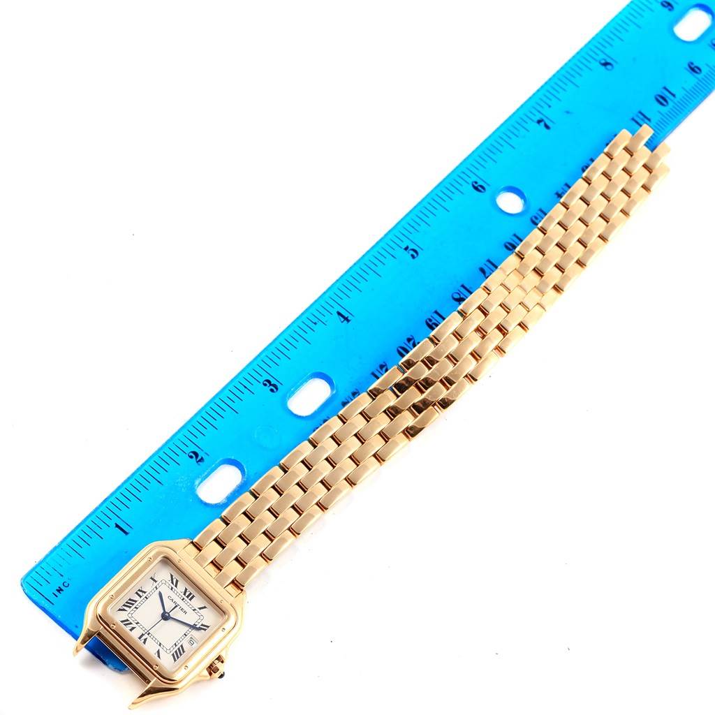 The image shows a Cartier Panthere W25014B9 Yellow Gold Silver Dial W25014B9 Yellow Gold Silver Dial watch laying flat with its face and bracelet visible next to a blue ruler for scale.
