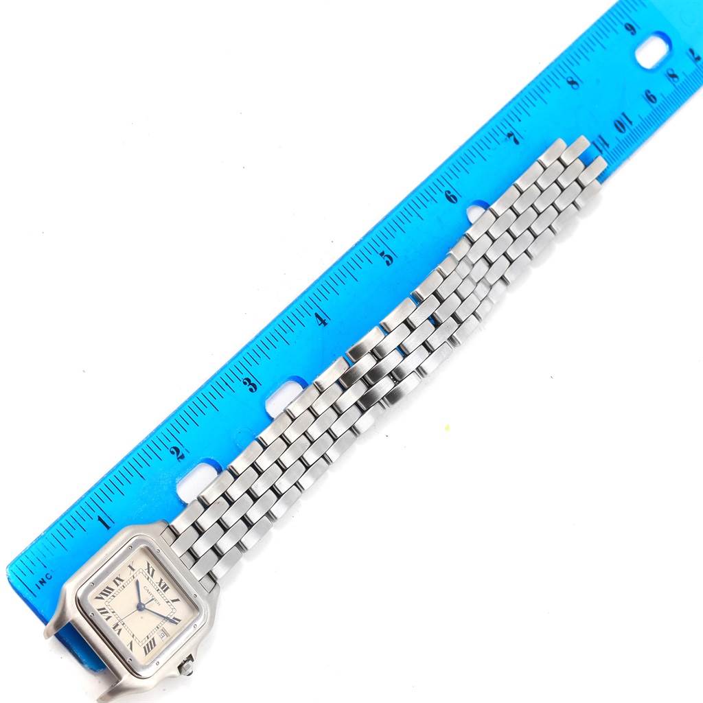 This image shows the Cartier Panthere W25032P5 Men
s Stainless Steel Silver Dial W25032P5 Men
s Stainless Steel Silver Dial watch laid flat beside a blue ruler.