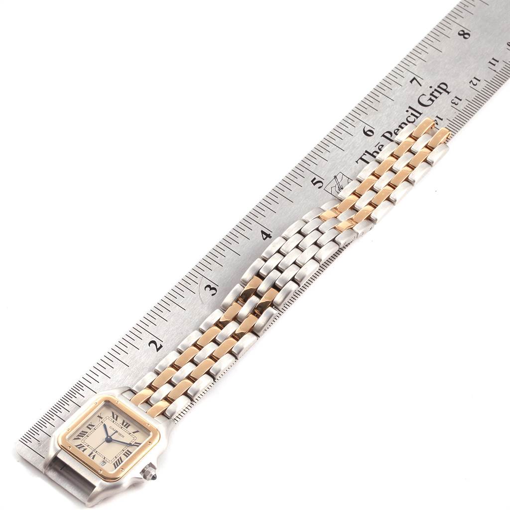 The Cartier Panthère watch is shown from a top-down angle alongside a ruler, highlighting its band and face.